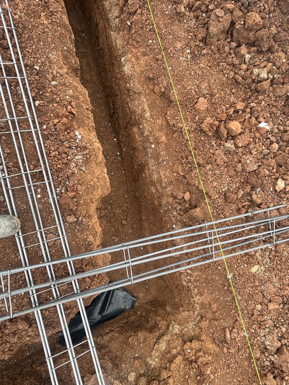 Vapour barrier not carried under the whole slab, recorded on a slab pre-pour inspection in Fraser Rise